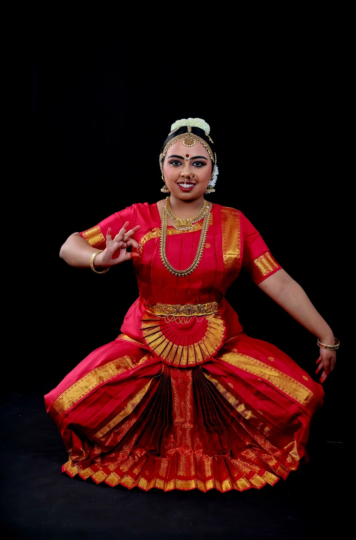 Shreya seated in a wide pose with one hand extended and focused expression for the Ayyappa Padam